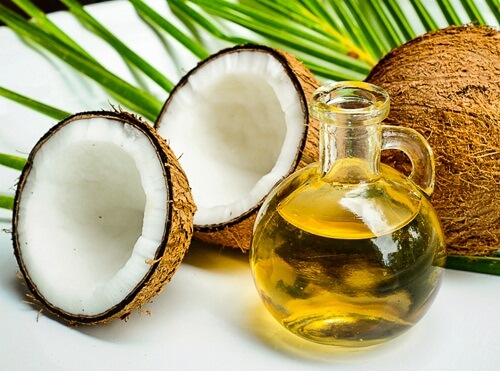 Offene Kokosnuss und Kokosöl in der Flasche
