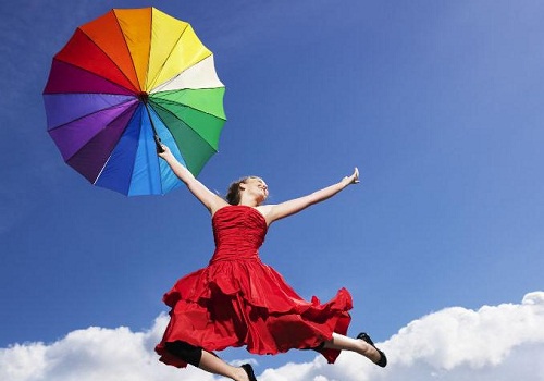 Frau springt mit Regenbogenschirm in die Luft