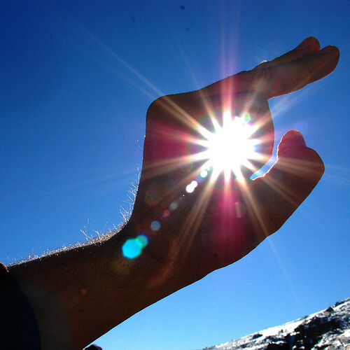 Hand, blauer Himmel und blaues Licht