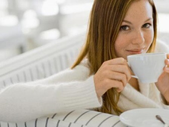 Frau trinkt warmes Wasser aus Tasse