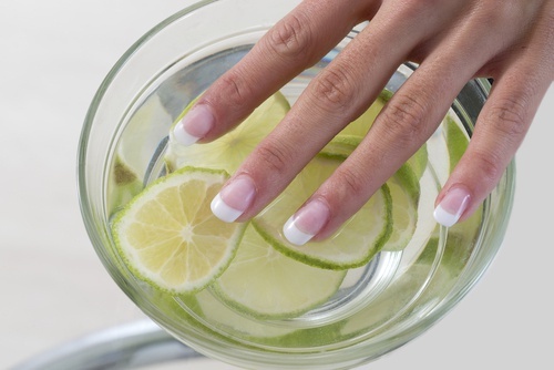Finger in Wasser mit Zitronen baden