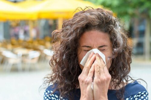allergischer Schnupfen - Frau putzt sich die Nase