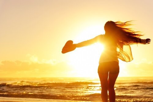 Frau genießt das Meer mit ausgebreiteten Armen und sucht ihren Weg
