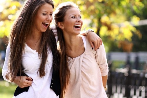 2 Frauen gut gelaunt Arm in Arm mit schönem Körper