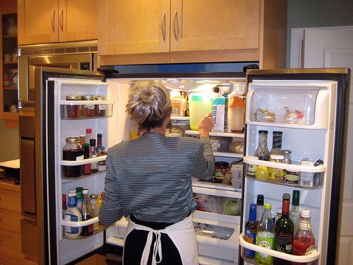 Frau vor offenem Kühlschrank