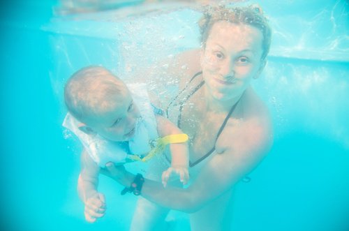 Frau mit Baby im Kaltwasserbad in den Ferien