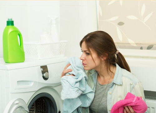 Frau wäscht Wäsce und verwendet Weichspüler