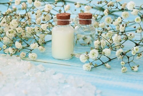 Magnesiumfläschchen und Blumen Heilsalbe