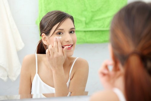 frau-schaut-in-den-spiegel-und-entfernt-make-up
