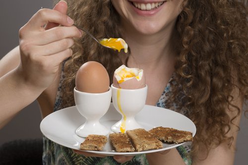 frau-isst-fruehstuecksei-appetit