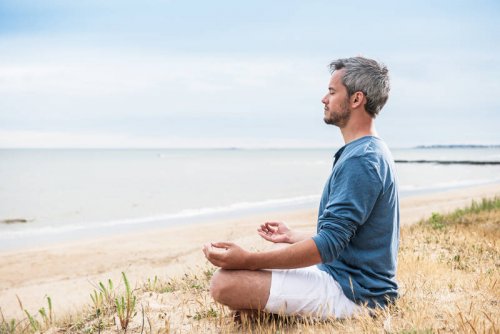 Mann meditiert am Strand und hat Ideen