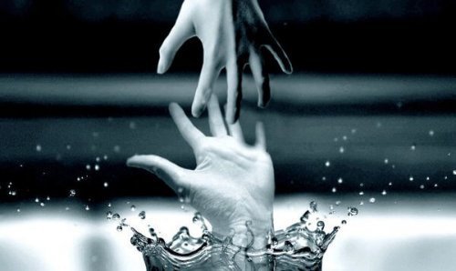 Hand greift aus dem Wasser nach anderer Hand