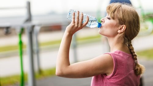 Frau in der Menopause trinkt Wasser