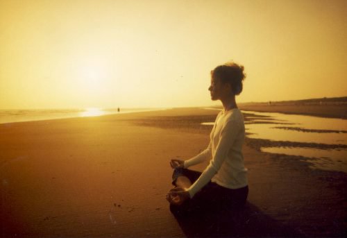 Frau macht Meditation am Strand