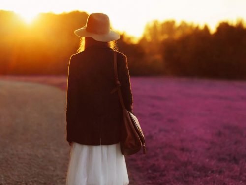 Frau spaziert am Abend in freier Natur