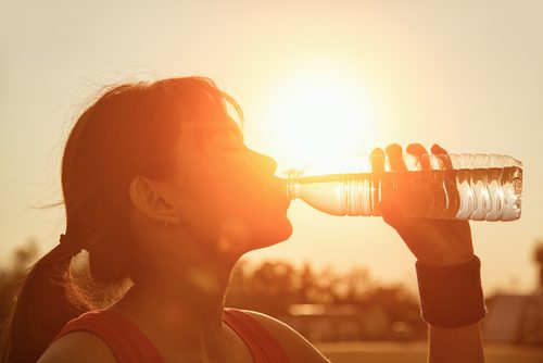 Frau trinkt Wasser zur besseren Fettverbrennung