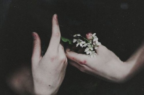 Hände mit Blumen symbolisieren eine Frau auf dem Weg der Bewältigung von Emotionen