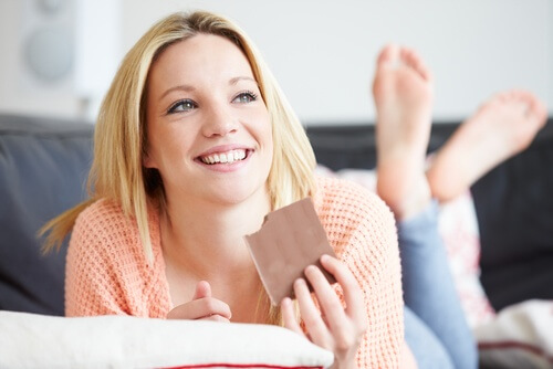 Warum Magnesium? Frau isst Schokolade für ihre Knochengesundheit
