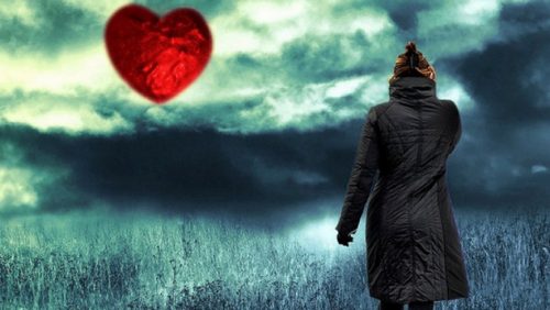 Eine Frau sieht ein rotes Herz am Horizont. Innerer Frieden ist nah.