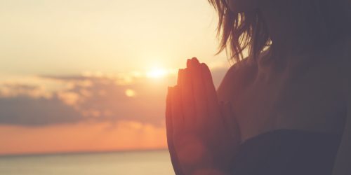 Frau grüßt mit Namaste