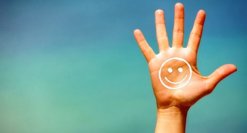 Hand mit Smilie als Symbol um Negatives in Positives zu verwandeln