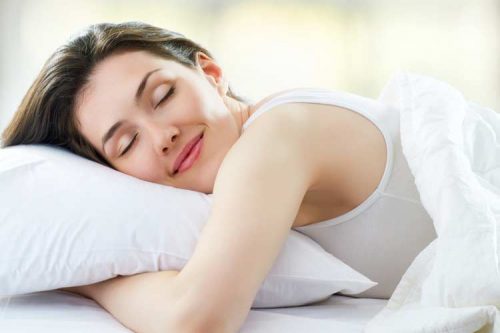 Frau schläft gut weil sie täglich Honig konsumiert