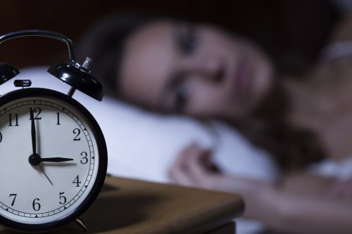 Frau im Bett weiß, dass Diabetes zu Schlafstörungen führen kann