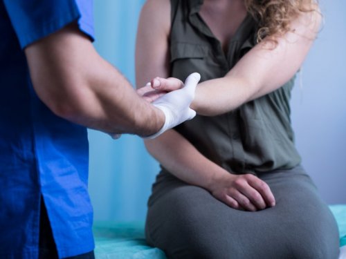  Frau beim Arzt leidet an schlecht heilenden Wunden an den Händen