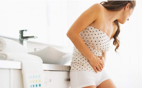 Eine Frau mit einer Blasenentzündung als Frühwarnzeichen für Diabetes hält sich den Unterleib.