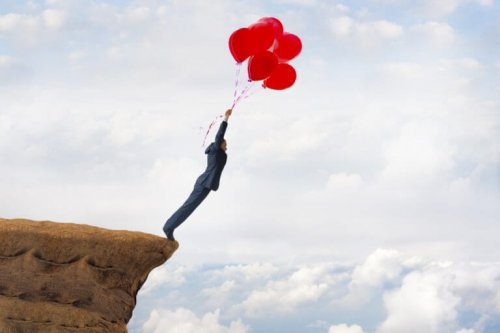 Mann hat ungelöste Probleme und hält sich an roten Luftballons