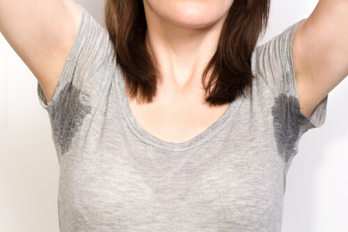 Frau will Schweißflecken aus Textilien entfernen