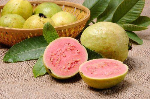 Es liegen ein paar Guaven in einem Korb und ein eine aufgeschnitte Frucht direkt davor.