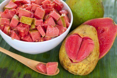 Eine Schüssel ist mit aufgeschnittenen Guaven gefüllt, daneben liegt eine Guave mit einem eingeritzten Herzen.
