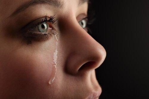 Nahaufnahme einer Frau, der Tränen das Gesicht herunter rollen.