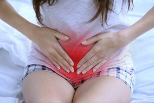 Eine Frau hält sich ihren rot gekennzeichneten Unterleib, der wegen ihrer Menstruation schmerzt.