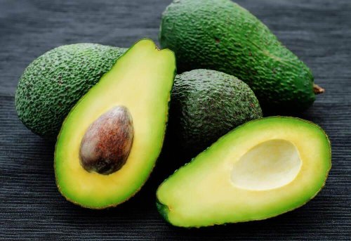 Drei Avocados und eine vierte, aufgeschnittene Avocado sind abgebildet.