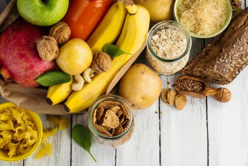 Es sind gesunde Kohlenhydrate abgebildet, in Form von Bananen, Walnüssen, Äpfeln und mehr.