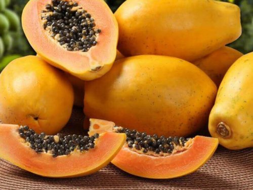 Die gesündesten tropischen Früchte: Abgebildet ist ein Haufen an Papayas, wobei eine davon aufgeschnitten ist.