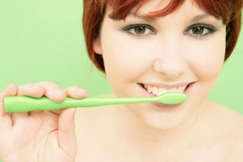Frau benutzt natürliche Zahnpasta