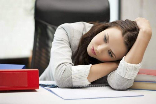 Eine Frau mit Depressionen sitzt an ihrem Schreibtisch.