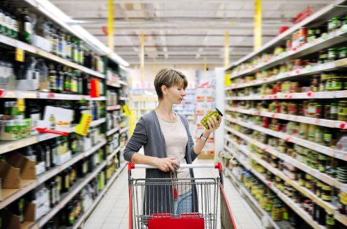 Eine Frau mit einem Einkaufswagen im Supermarkt.