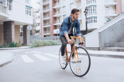 Ein Mann fährt mit seinem Fahrrad die Straße entlang.