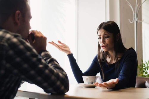 Eine verärgerte Frau sitzt in einem Cafe und spricht mit ihrem Freund.