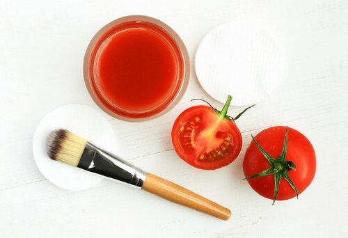 Eine Schale Tomatensaft, zwei Tomaten, ein Pinsel und Wattebäusche sind abgebildet.