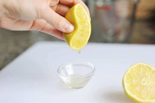 Eine Zitrone wird in eine kleine Schüssel ausgepresst.