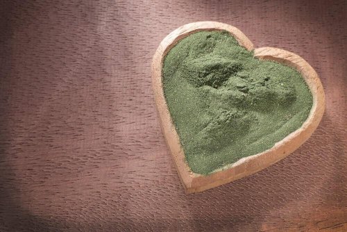 Pulver aus Spirulina in einer herzförmigen Schüssel.