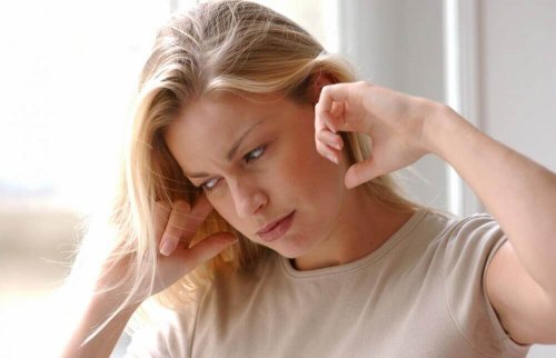 Frau hält sich die Ohren zu, weil sie Heilmittel gegen Ohrenschmerzen braucht.
