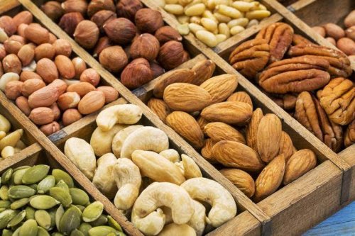 Verschiedene Nüsse in kleinen Boxen, wie Mandeln, Cashews oder Pinienkerne.