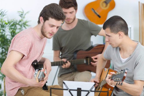 Jugendliche spielen zusammen Gitarre