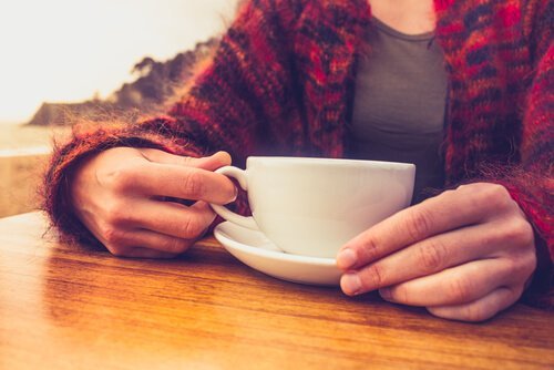 Hände halten Kaffeetasse